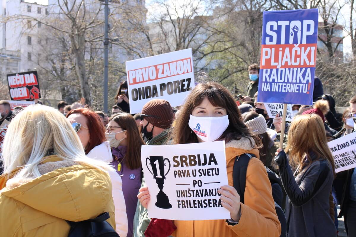 Demonstratkinja sa transparentom na protestu frilensera